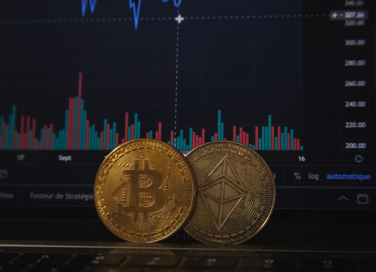 Bitcoin and Ethereum coins in front of a trading chart